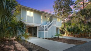 A two-story house with a front porch, a staircase, and a driveway. - Palm-surrounded abode with screened-in balcony, chef's kitchen, smart TVs, & W/D (Isle of Palms)