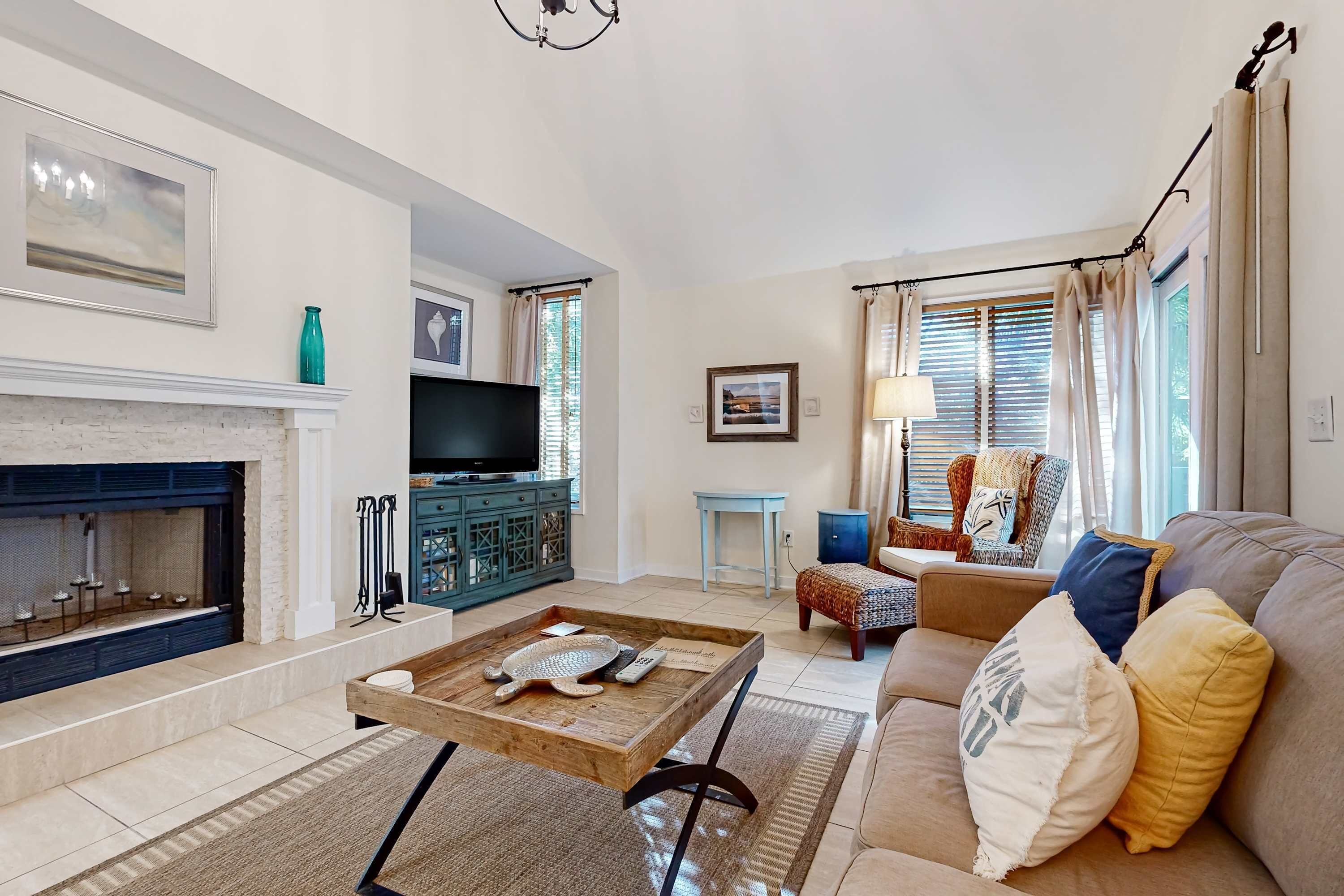A living room with a fireplace, a television, a sofa, and a coffee table.