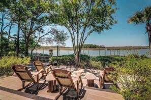 Une terrasse avec des sièges et une vue sur un plan d’eau.