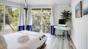 A bedroom with a bed, a desk, a computer, and a window with curtains. - Lakefront home with lagoon view, deck & AC - close to beach, golf, & pools (Seabrook Island)