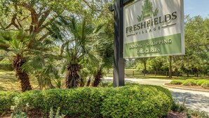 Placa de Freshfields Village anunciando restaurantes, lojas e mantimentos.