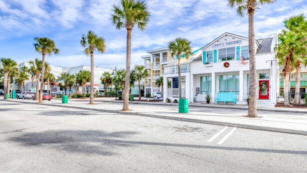 A street with palm trees, a white building with a sign reading "Papi's Taberna," and a red door. - Townhouse-style villa with screened porch & pool access - short walk to beach (Isle of Palms)
