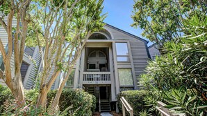 A two-story building with a balcony and a staircase leading to the entrance. - Beach villa with full kitchen, ocean/inlet views - short walk to Beach Club (Seabrook Island)