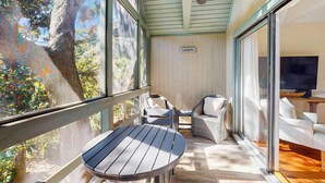 Un área de estar al aire libre techada con una mesa, sillas, un televisor y un letrero que dice "Galayda".