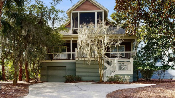 A two-story house with a front porch, a covered entryway, and a staircase leading to the upper floor. - Spacious home with pool - walk to beach & golf (Kiawah Island)
