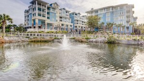 A hotel with multiple floors, a central courtyard with a fountain, and a pool area. - Elegant home on the boardwalk with 2 balconies & shared pools - walk to beach (Isle of Palms)
