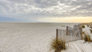 A sandy beach with a wooden fence and sparse vegetation. - Elegant home on the boardwalk with 2 balconies & shared pools - walk to beach (Isle of Palms)