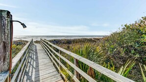 A wooden boardwalk leading to a beach with a clear sky. - Oceanfront, event-friendly home with multiple decks & WiFi - 2 dogs ok (Folly Beach)