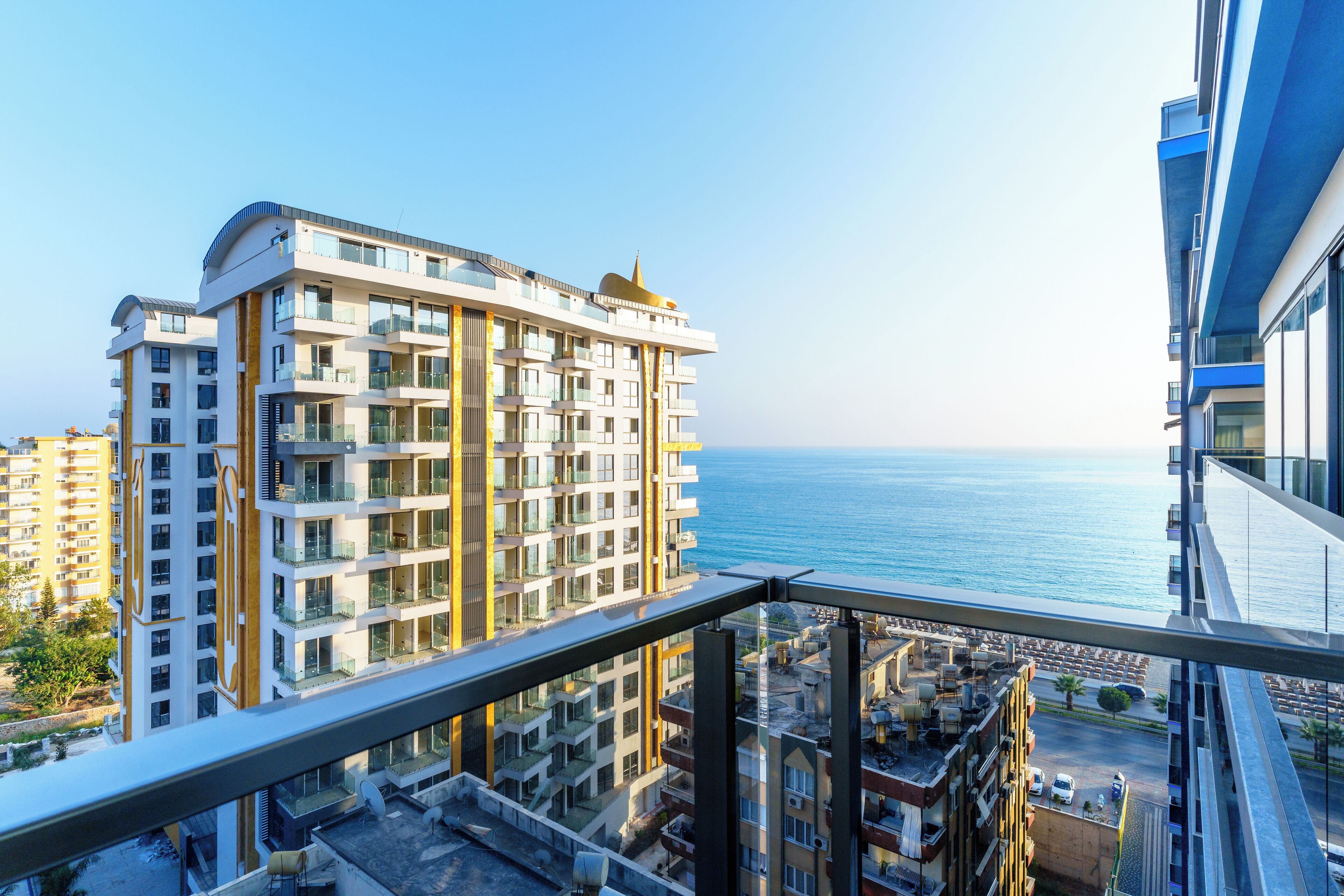 Un immeuble de grande hauteur doté de nombreux balcons donnant sur une zone côtière.