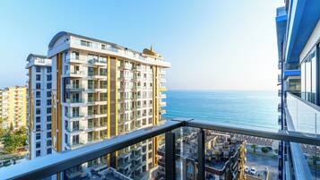 Un immeuble de grande hauteur doté de nombreux balcons donnant sur une zone côtière.