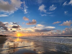 A beach with a sunset, waves, and a clear sky. - Spacious, dog-friendly home with screened porch, next to the beach path (Kiawah Island)
