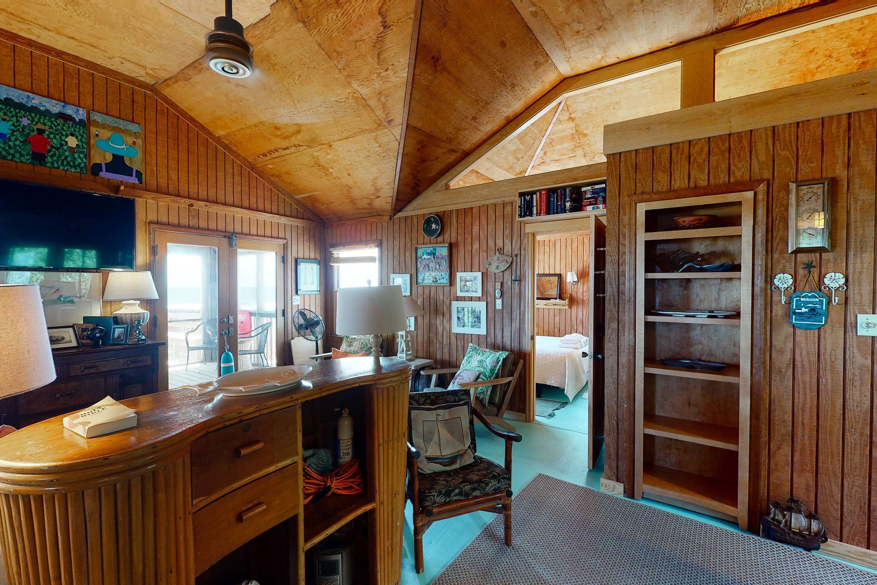 A wooden interior with a desk, chair, and shelves.