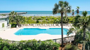 A pool with a view of the beach and a pier. - Beachfront condo with pool, beach access, pier, private balcony, & central AC (Isle of Palms)