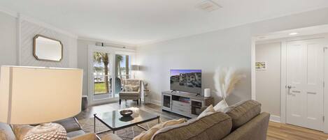 Una sala de estar moderna con sofá, mesa de centro y televisor.