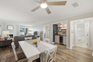 A spacious living area with a dining table, seating, and a view to the outside.