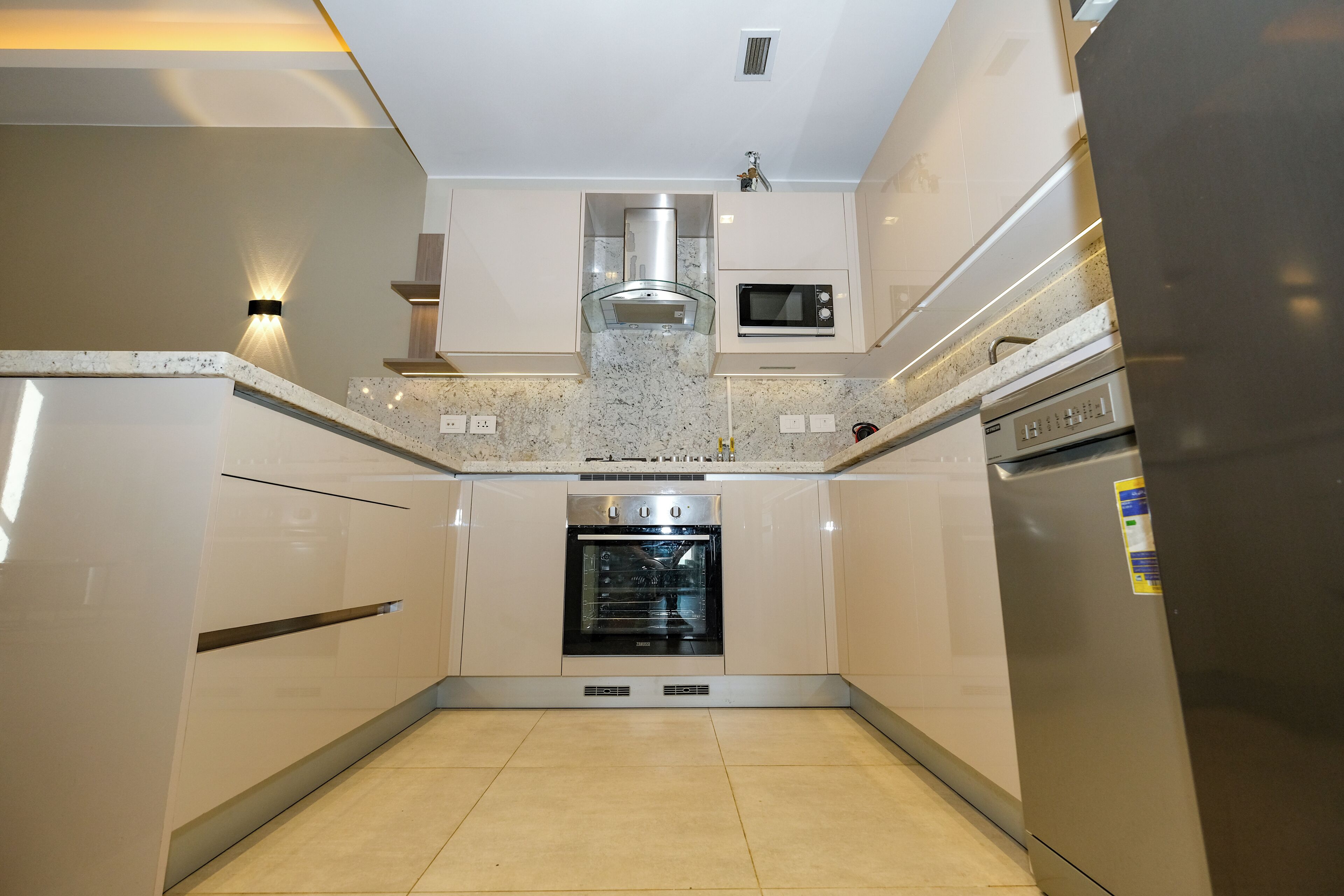 A modern kitchen with built-in appliances, including a microwave, oven, and refrigerator.