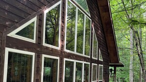 A wooden cabin with large windows and a deck. - Hartford Hideaway! Soothing cabin in the Smokies. (Hartford)