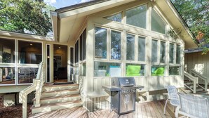 A covered deck with a grill and outdoor seating. - Remodeled Home with Deck, Sun Porch & In-Law Suite - Dogs OK, Beach Nearby (Kiawah Island)