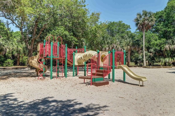 A playground with a slide, climbing structures, and a sandpit.