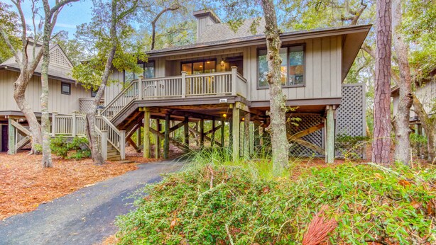 A two-story wooden house with a covered porch and a staircase leading to the upper level. - Scenic view cottage w/ Free Wifi - just a short walk to the beach & park (Kiawah Island)