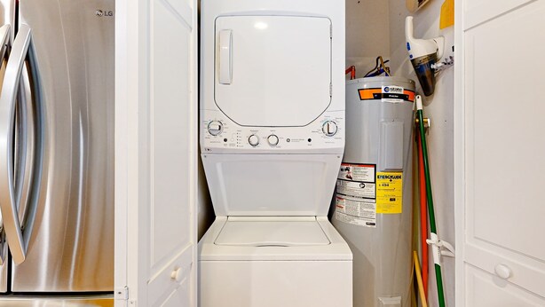 A compact laundry room with a stainless steel refrigerator, a washing machine, and a water heater. - Dog-friendly home with deck, grill & pool - easy walk to beach, dining & shops (Kiawah Island)