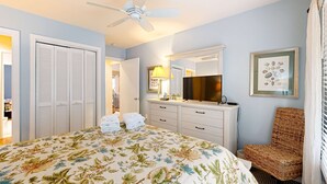 A bedroom with a bed, a dresser, a chair, a ceiling fan, and a framed picture on the wall. - Dog-friendly home with deck, grill & pool - easy walk to beach, dining & shops (Kiawah Island)