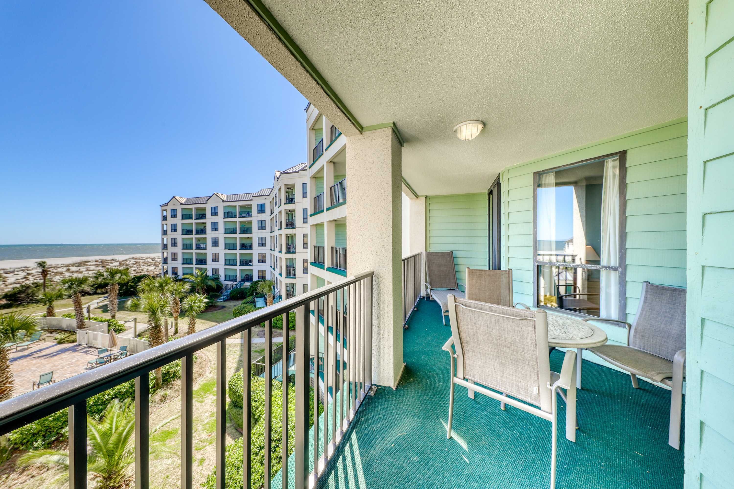 Un balcon avec vue sur la plage et les autres bâtiments.