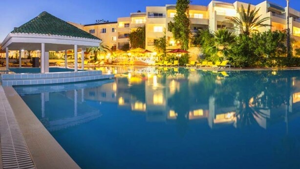 A swimming pool with a gazebo and umbrellas, surrounded by buildings and greenery. - regency hammamet (Hammamet)