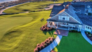 A coastal property with a large house, a well-maintained lawn, and a golf course. - Cozy Kiawah Island villa centrally located near local attractions (Kiawah Island)