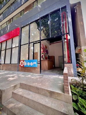 A building with large windows, a reception desk, and a staircase leading to the entrance. - Edificio Bloom (Medellín)