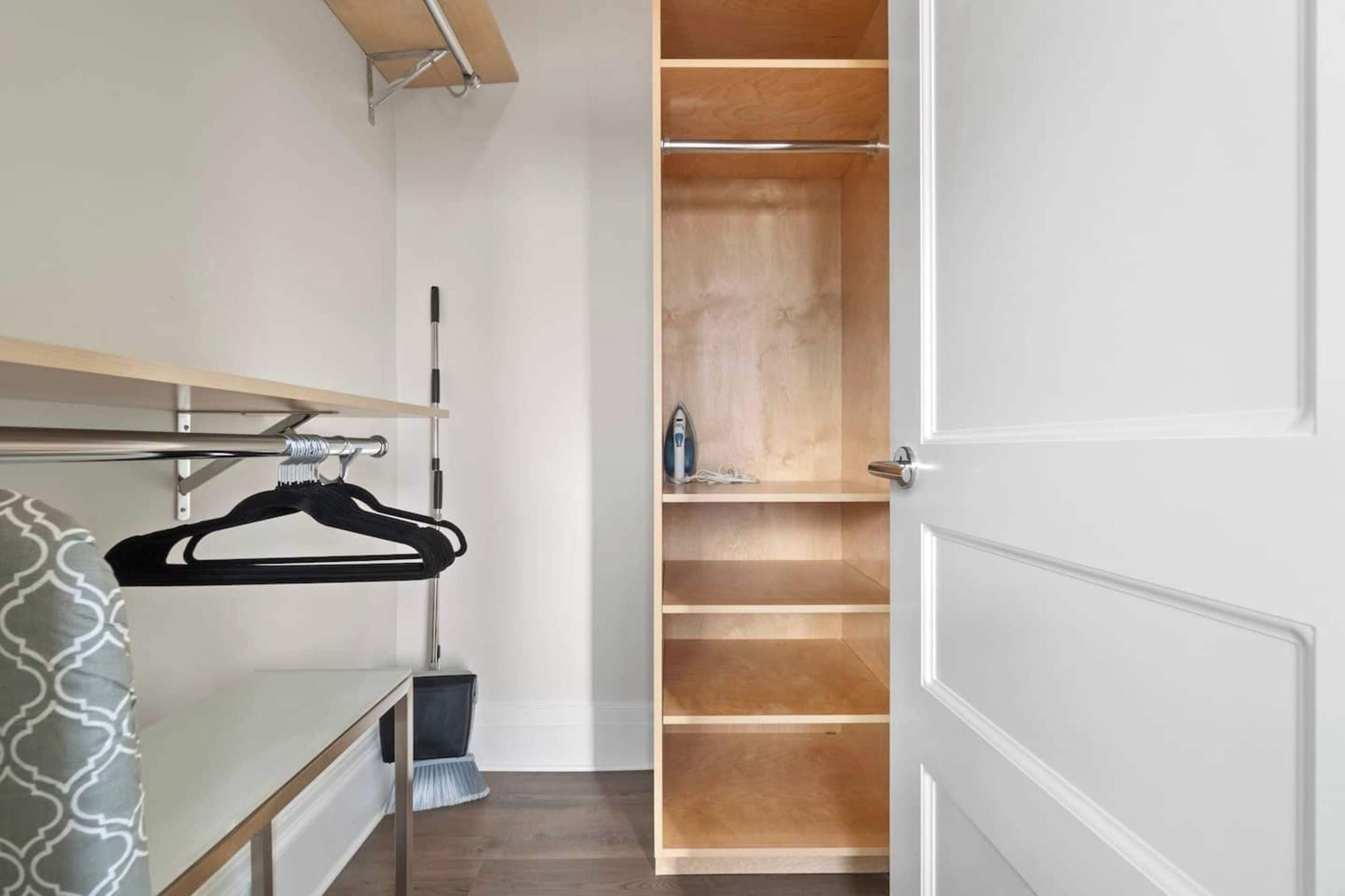 Un armario de vestidor con estantes de madera y una barra para colgar.