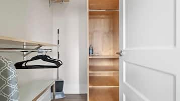 A walk-in closet with wooden shelving and a hanging rack.
