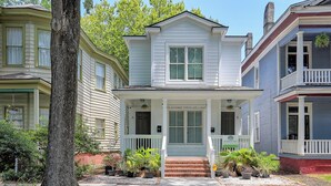 A two-story house with a front porch, a sign indicating 'Home Buyers,' and a brick foundation. - The Peach House- Near Downtown (Savannah)