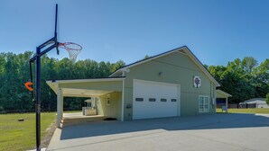 A single-story building with a garage, a covered parking area, and a basketball hoop. - Southern Comfort Near Historic Dtwn Rockmart (Rockmart)