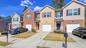 A row of townhouses with attached garages, a clear driveway, and a mailbox. - Pets Welcome! Family Townhome w/ Yard in Atlanta (Atlanta)
