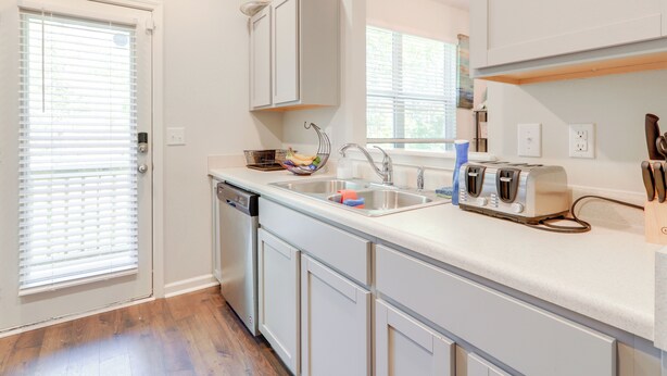 A kitchen with white cabinets, a dishwasher, a sink, and a toaster. - Pets Welcome! Family Townhome w/ Yard in Atlanta (Atlanta)