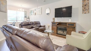 A living room with leather sofas, a television, and a fireplace. - Pets Welcome! Family Townhome w/ Yard in Atlanta (Atlanta)