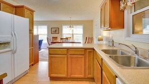 A kitchen with wooden cabinets, a double sink, and a refrigerator. - Peaceful & Convenient Country Retreat in Lexington (Lexington)
