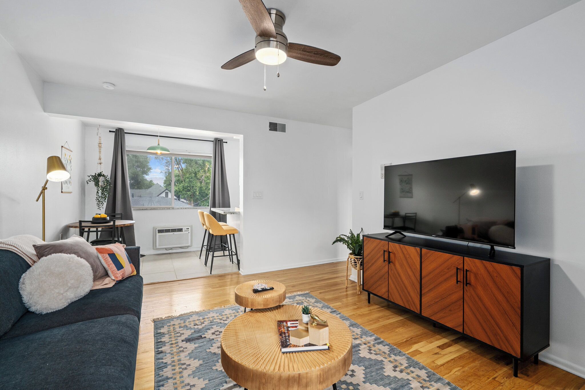 A modern living room with a sofa, coffee table, TV, and wooden cabinet.