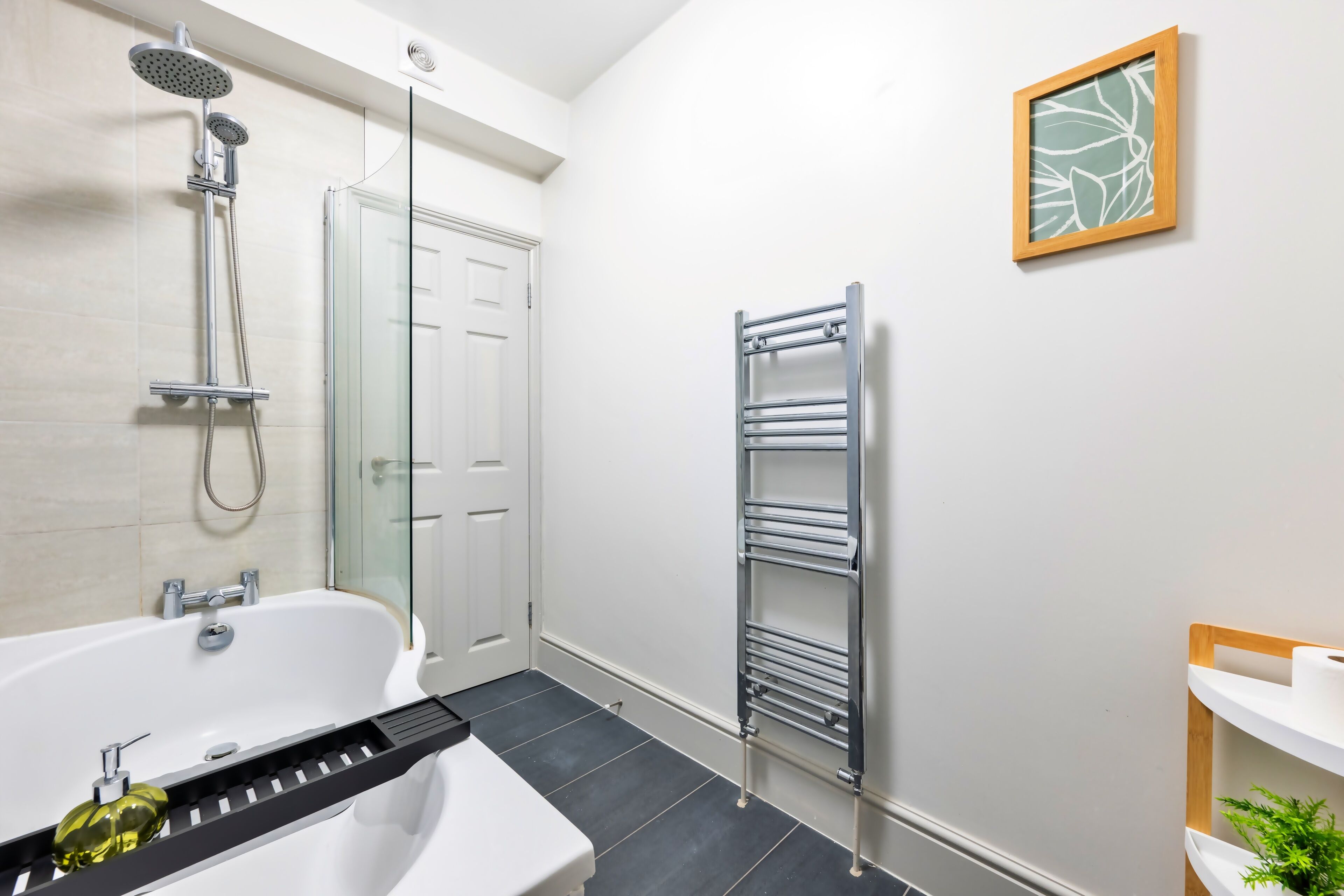 Ein modernes Badezimmer mit einer Badewanne, Dusche und einem Handtuchhalter.