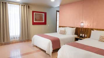 A hotel room with two beds, a nightstand, a telephone, and a framed picture on the wall.