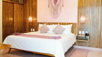 Une chambre d’hôtel avec un lit en bois, une table de chevet avec une lampe et un téléphone fixé au mur.