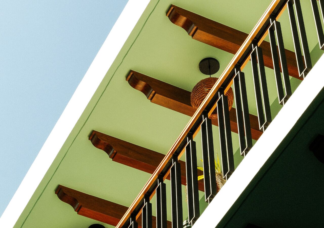 A staircase with wooden balusters and a green wall.