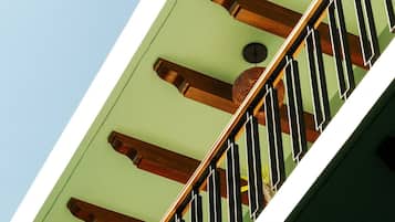 A staircase with wooden balusters and a green wall.
