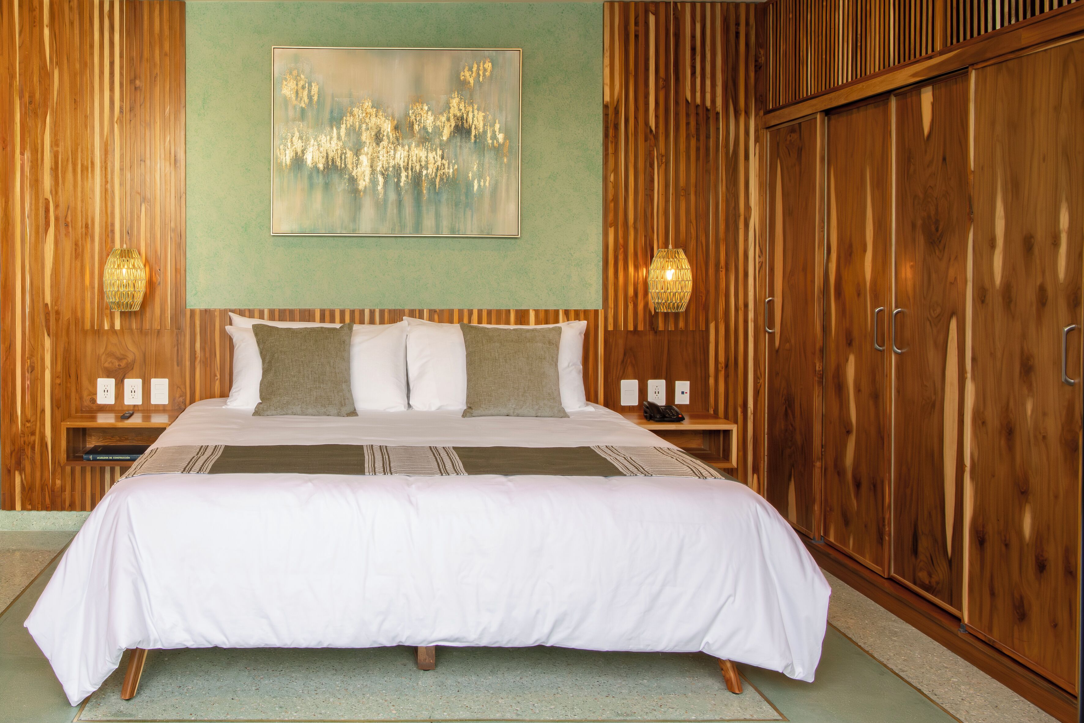 A large bed with white bedding, a headboard, and two bedside tables with lamps.