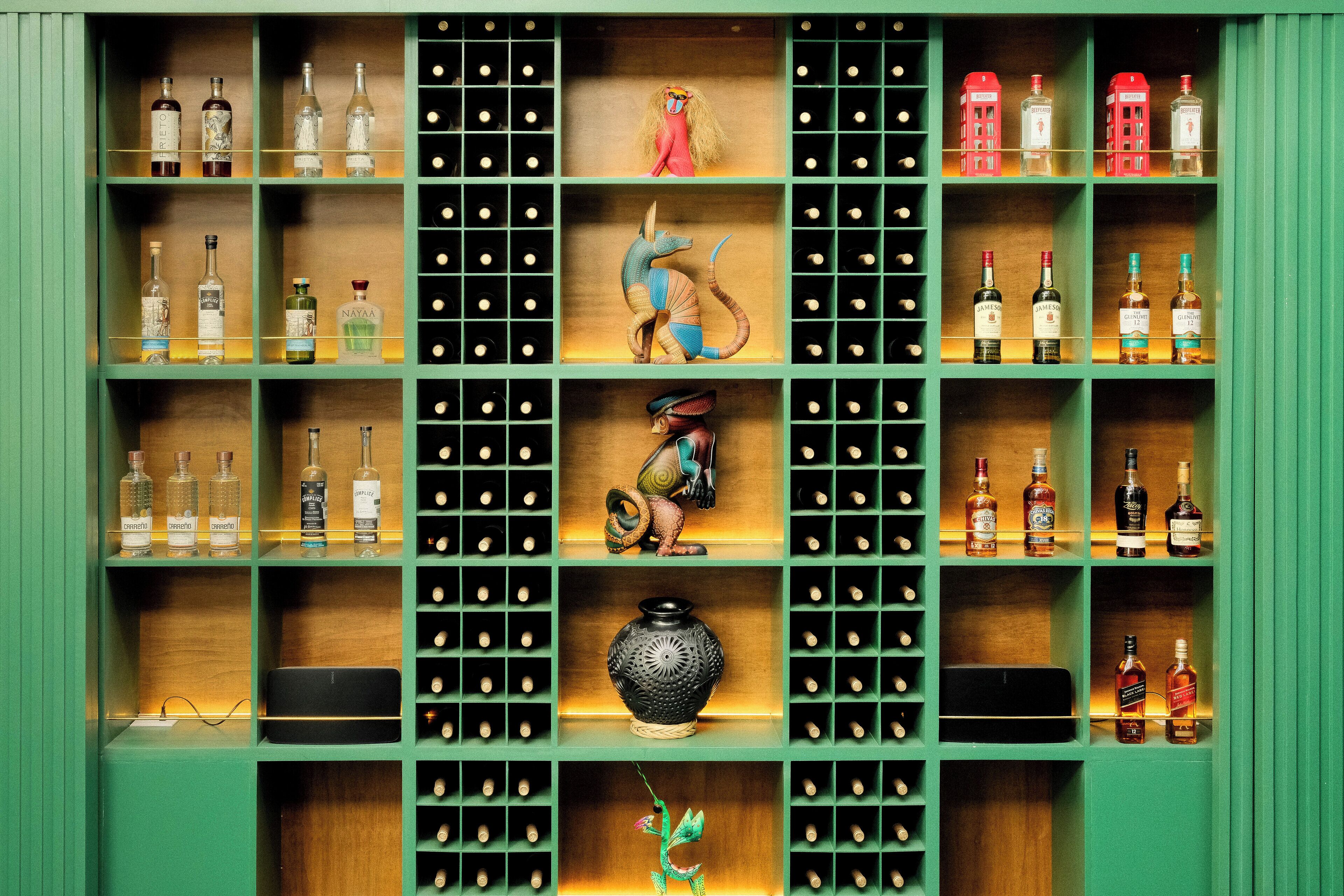 Un meuble à bouteilles contenant des bouteilles de vin et des objets décoratifs.