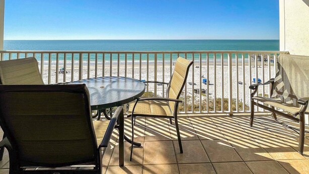 A balcony with a view of the beach and ocean.