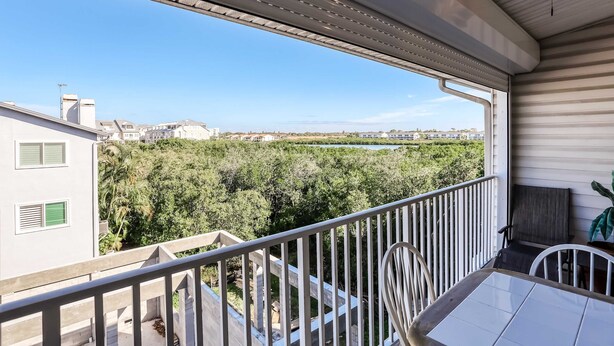 Un balcón con vista a una zona residencial y vegetación.