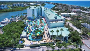 Un resort con un amplio espacio de piscina, parque acuático y vista al océano.