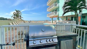 Ein Wohnbalkon mit Grill, Pool und Blick auf den Strand.